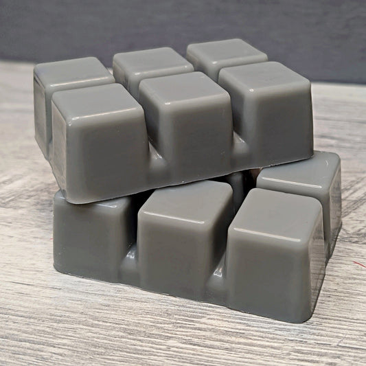 Stack of gray cube-shaped wax melts on a wooden surface