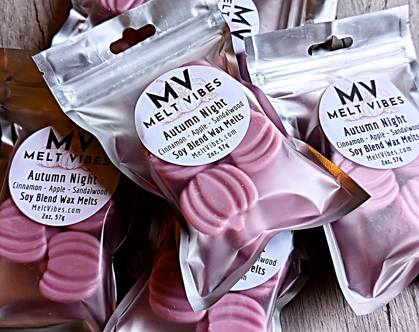 Pink pumpkin shaped wax melts in clear packaging with 'My Melt Vibes' labels on a wooden surface.