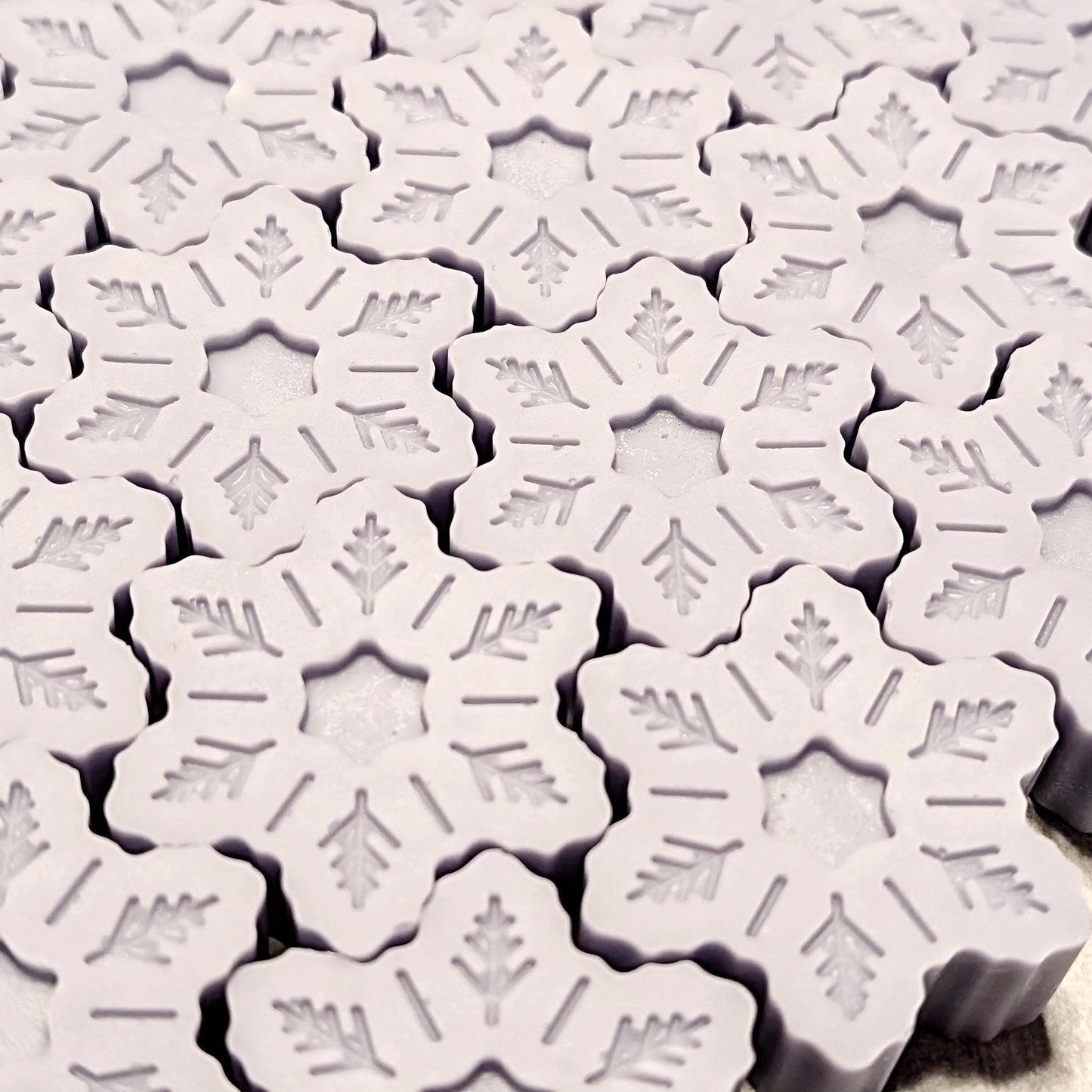 Close-up of snowflake-shaped wax melts on a white background
