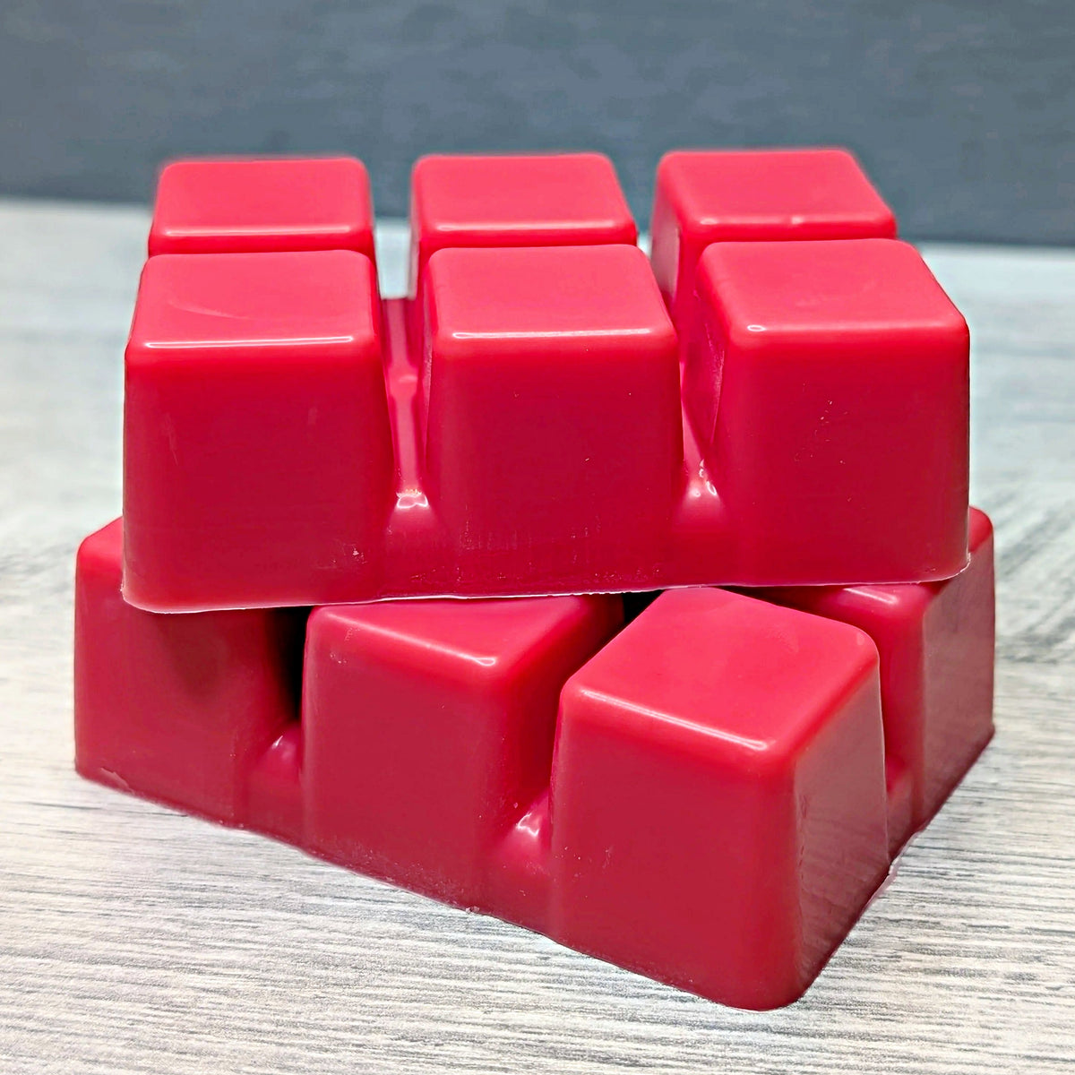 Stack of red wax melt cubes on a gray surface