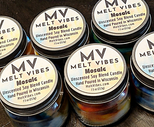 Multiple jars of Melt Vibes Mosaic unscented soy blend candles on a wooden surface.