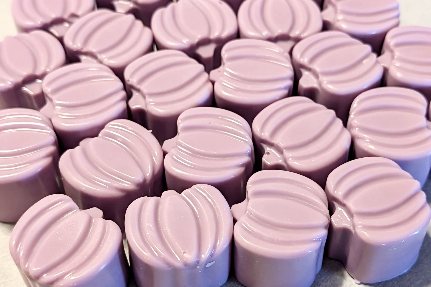 Close-up of purple pumpkin wax melts with a textured surface.