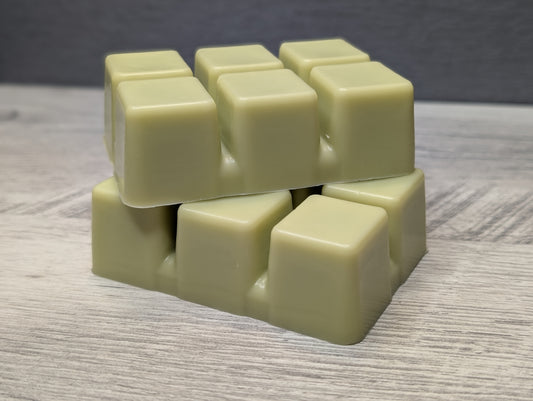 Stack of light green wax cubes on a wooden surface