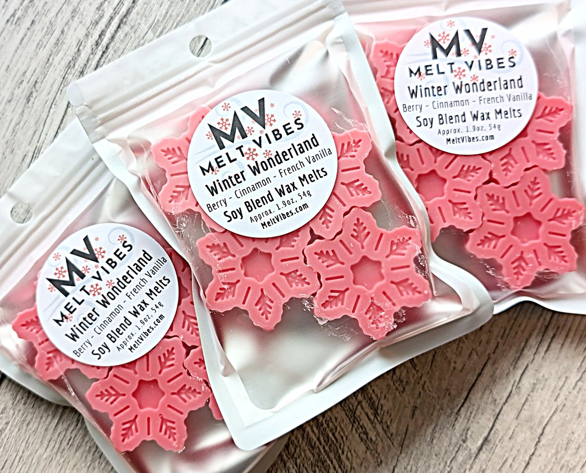 Pink snowflake-shaped wax melts in packaging with 'Melt Vibes' labels on a wooden surface.