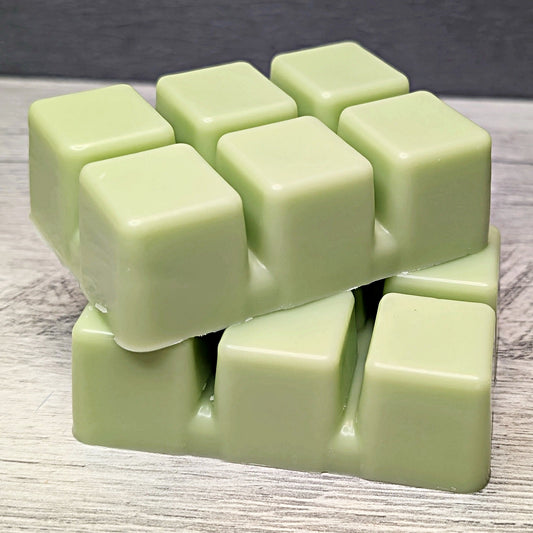 Light green wax melt cubes on a wooden surface