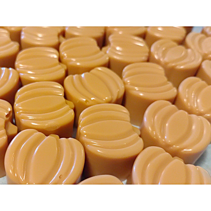 Orange pumpkin wax melts on a gray surface