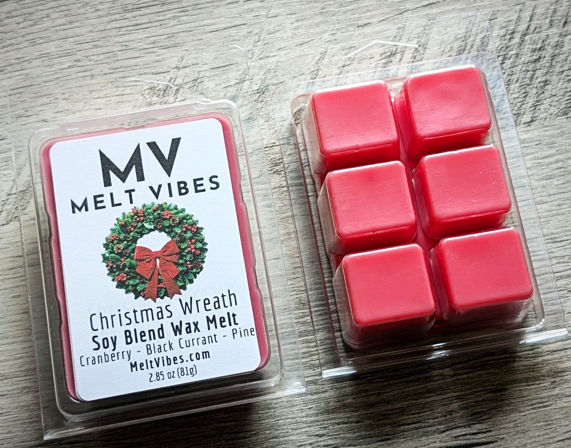 Red wax melts in a clear packaging with 'Melt Vibes' label on a wooden surface