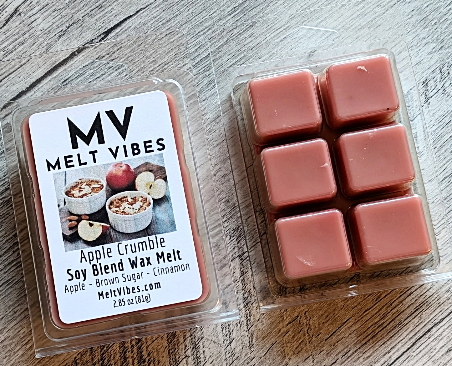 Wax melts in a clear container with a label for 'Melt Vibes' on a wooden surface.