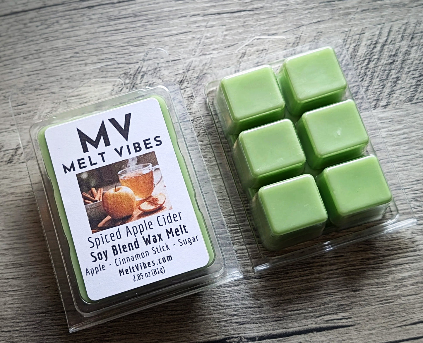 Green wax melts in a clear package with a label on a wooden surface