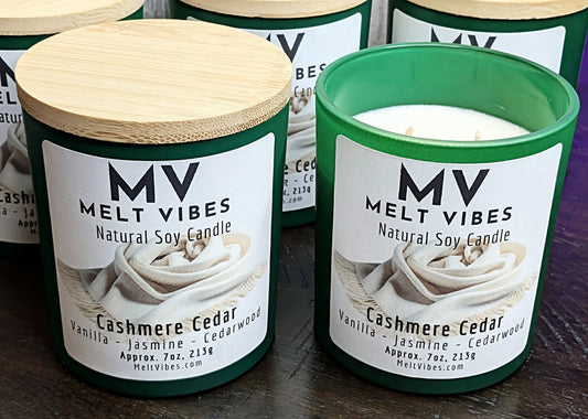 MV Melt Vibes cashmere cedar candles with wooden lids on a wooden surface.