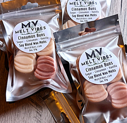 Packages of Melt Vibes Cinnamon Bun wax melts on a wooden surface