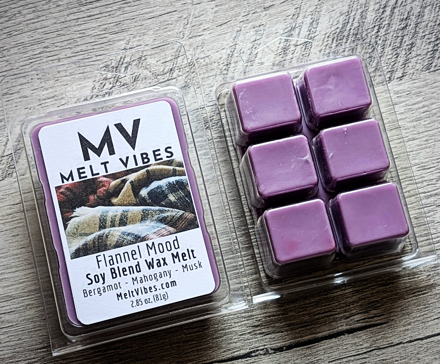 Purple wax melts in a clear container with a 'Melt Vibes' label on a wooden surface.