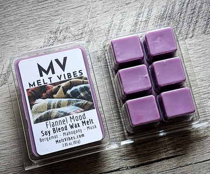 Purple wax melts in a clear container with a 'Melt Vibes' label on a wooden surface.