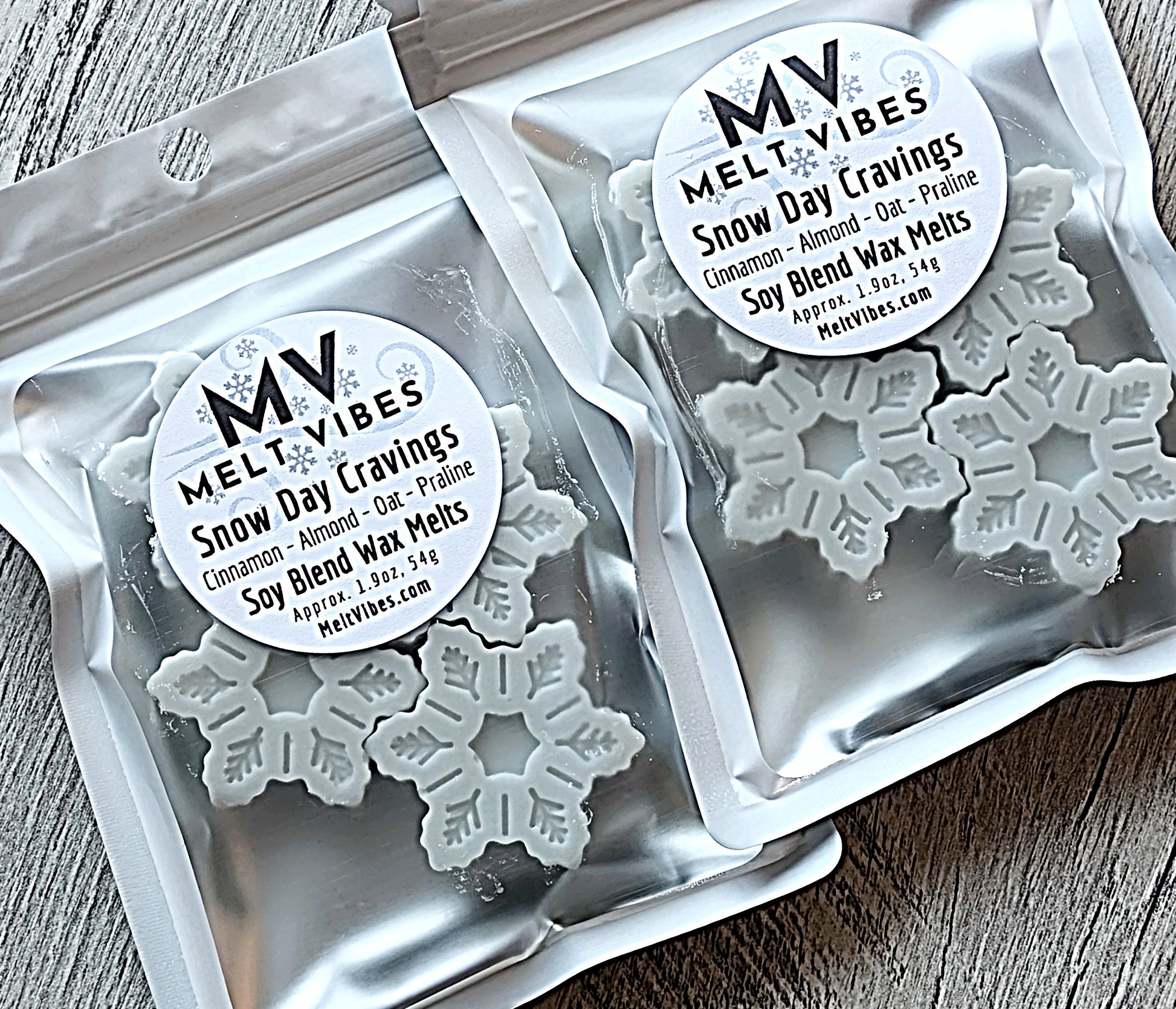 Silver bags of snowflake-shaped wax melts labeled "Melt Vibes Snow Day Cravings."
